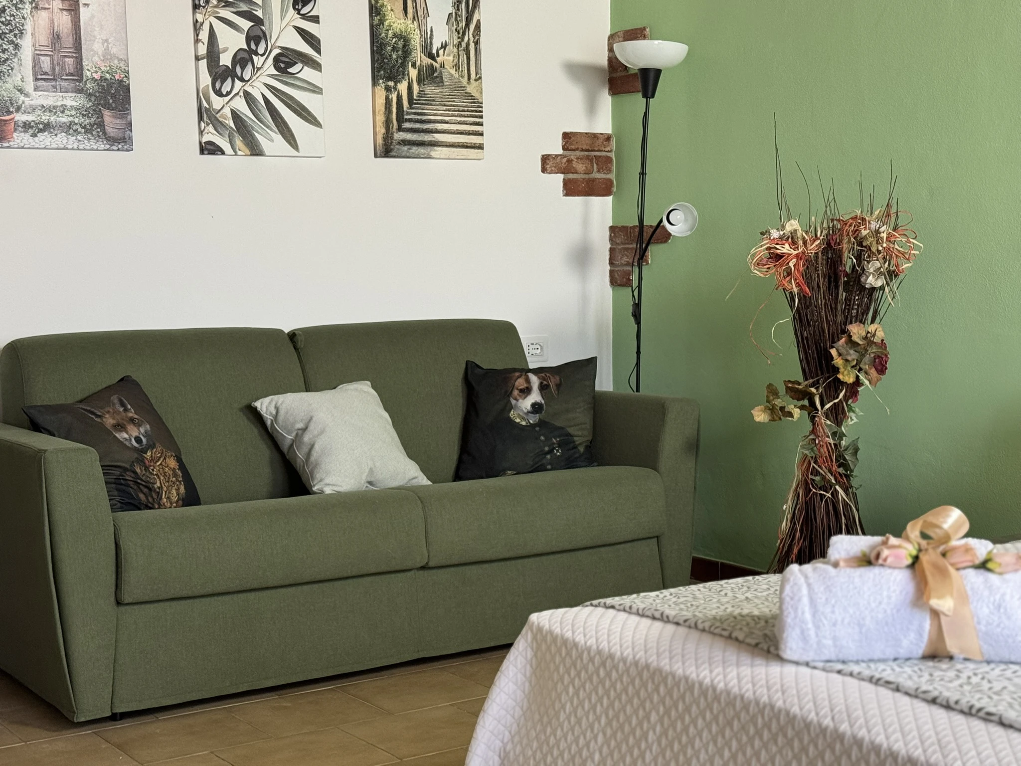Ein stilvolles Zimmer mit einer grünen Couch und einem Bett, das einen ruhigen und einladenden Raum für Erholung und Freizeit bietet.