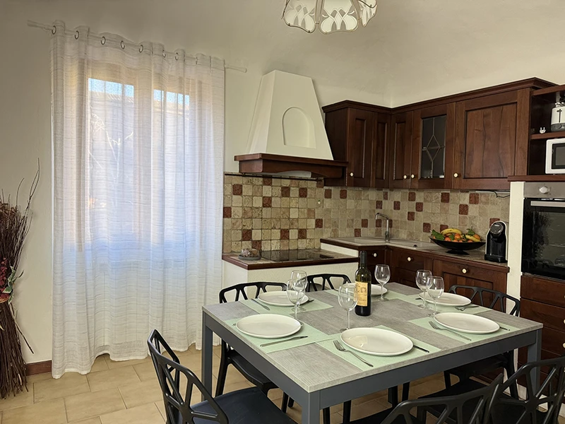 Eine charmante Küche mit einem einfachen Tisch und Stühlen, die einen einladenden Raum zum Kochen und gemeinsamen Genießen von Mahlzeiten schaffen.